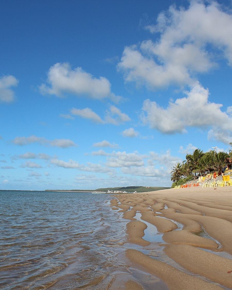 Praia da Barra de São Miguel com areia ondulada e água rasa