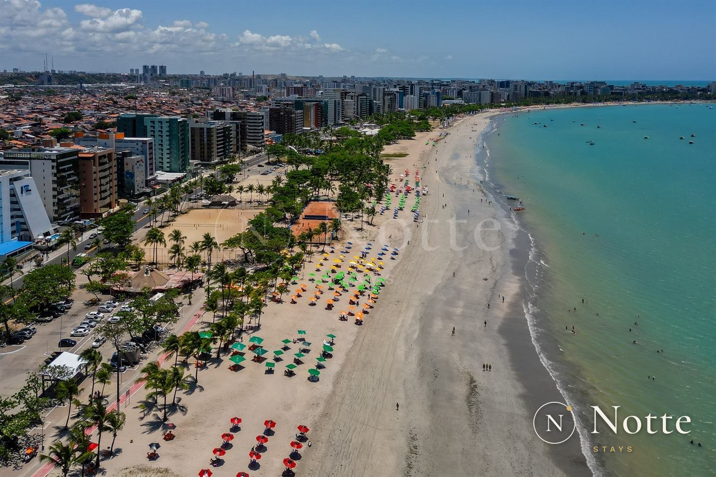 Orla da Pajuçara vista do alto, com coqueiros, areia clara e mar azul